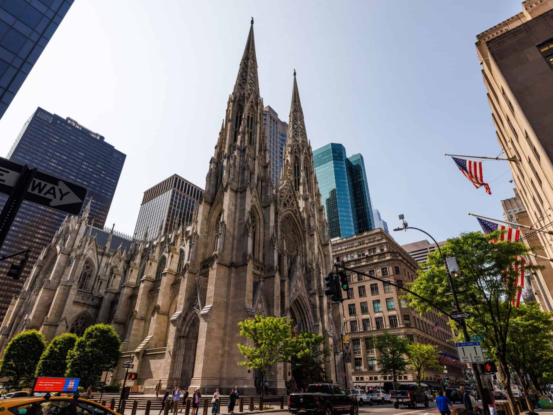 Street view of St. Patrick's Cathedral in New York with two tall spires framing the arched entrance.