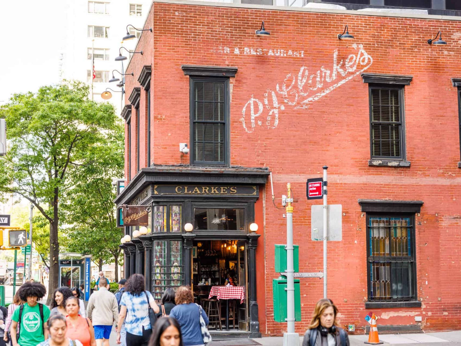 Street view of PJ Clarkes restaurant in New York. A red brick building with the company name above the entrance.