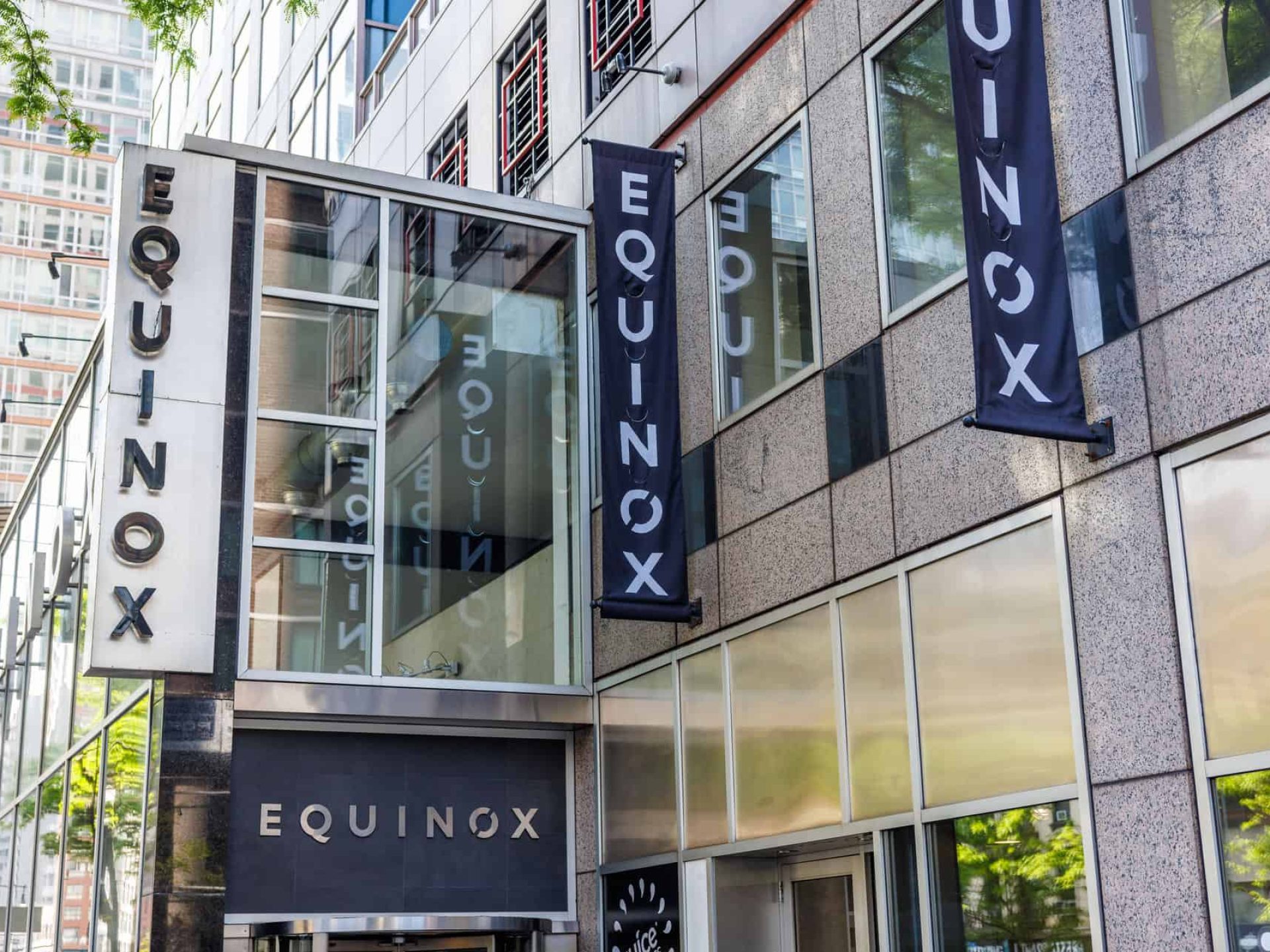 The Equinox gym in New York with large exterior windows and a company signs along the side of the building.