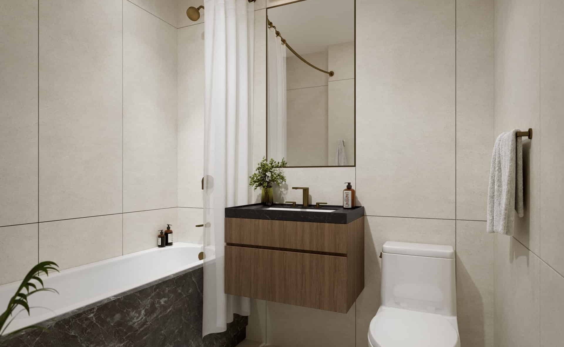 Bathroom at 340 East 52nd Street apartments with a floating single vanity, rectangle mirror, and a soaking tub with shower.